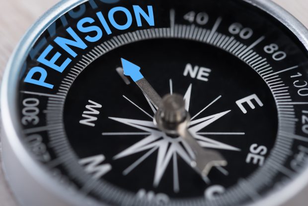 Close up of a compass, with the arrow pointing due north to the word pension.