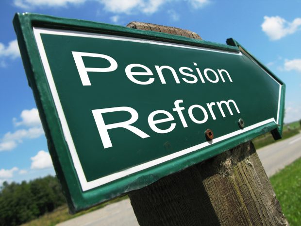 Roadsign on the side of a country road on a sunny day. Sign reads 'Pension Reform'.