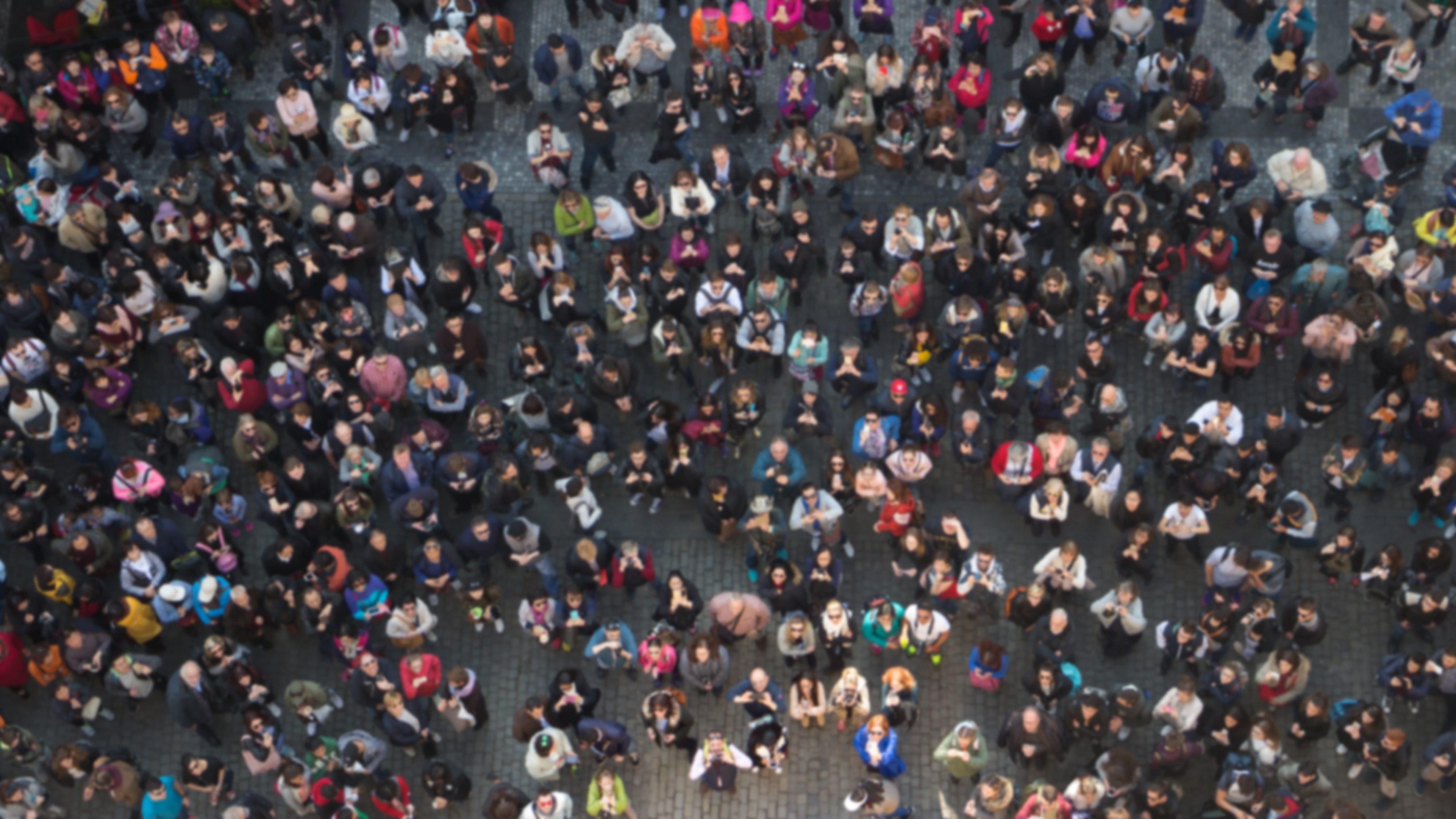 Aerial view of hundreds of people looking up at the camera