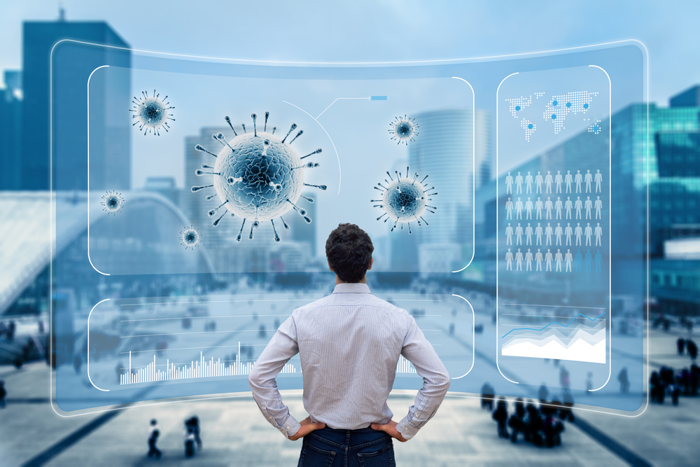 Back of a man who is staring at a 3D visualisation of the coronavirus, set against a cityscape,