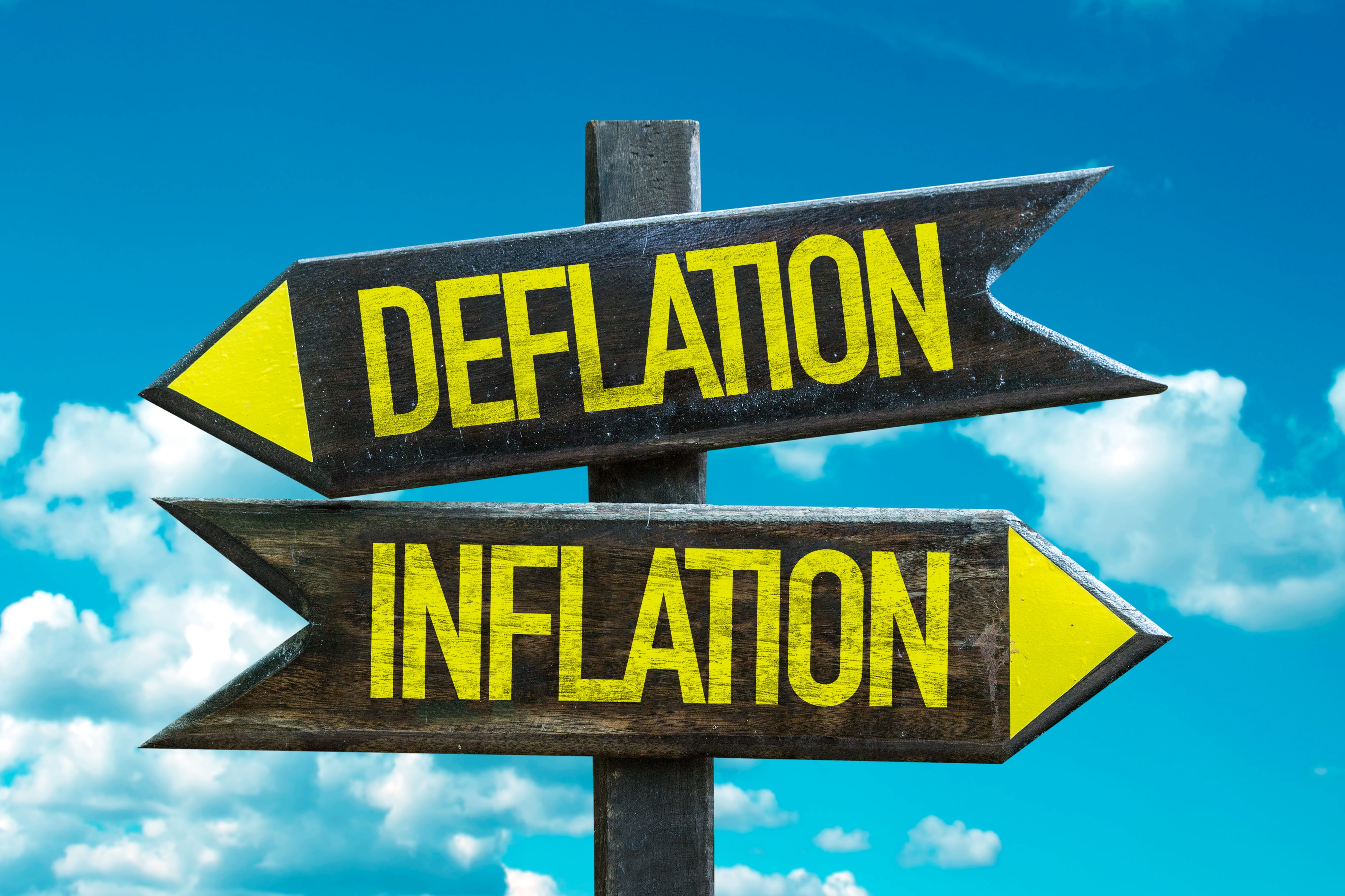 Signpost with 2 arrows - one is labelled deflation and the other one is labelled inflation.