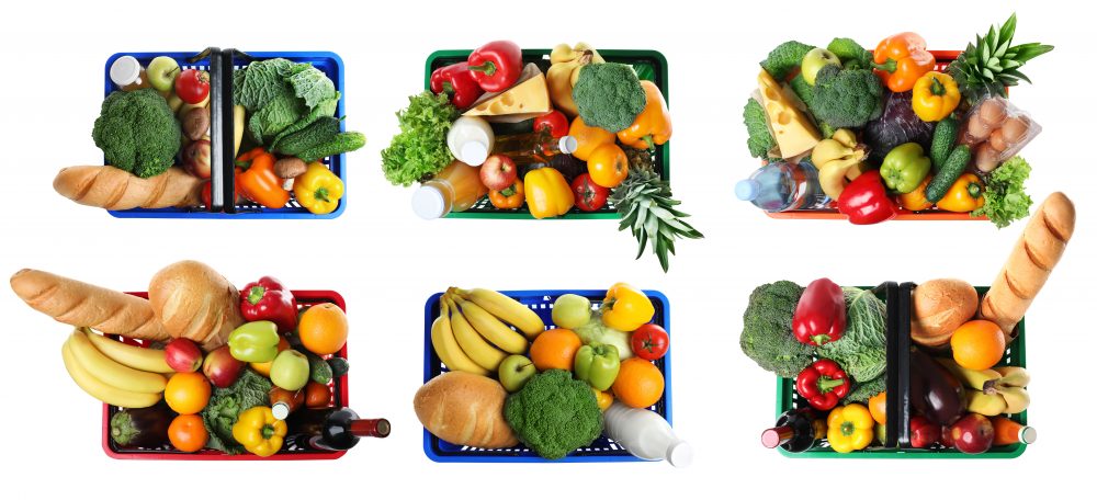 Six supermarket baskets with fruit, veg and bread in each one.