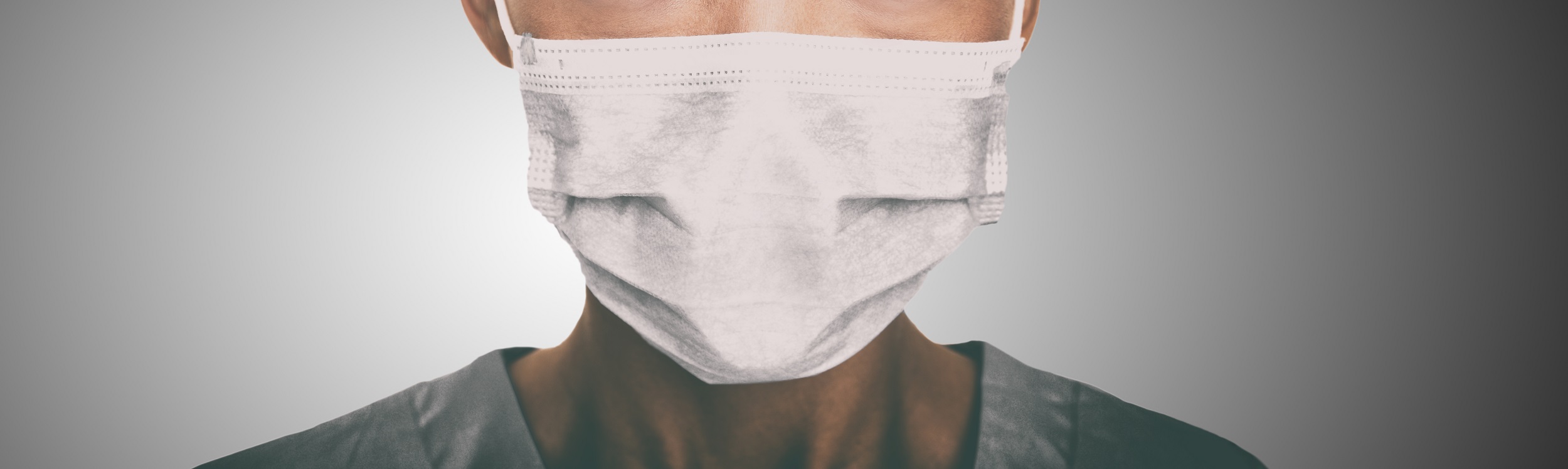 Lower half of a doctor's face, with a face mask.