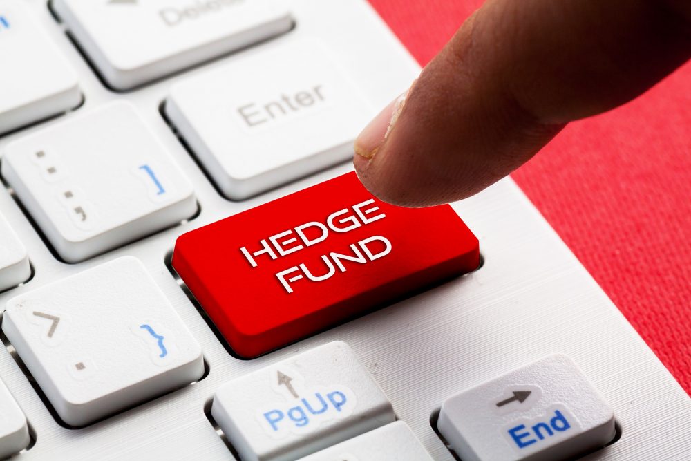 Close up of a man's index finger pointing to a computer button labelled Hedge Fund.