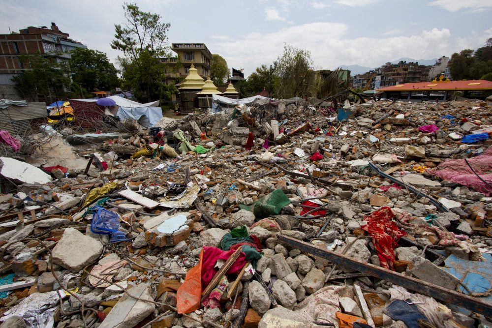 Aftermath of an earthquake. Rubble and clothing strewn over the ground.