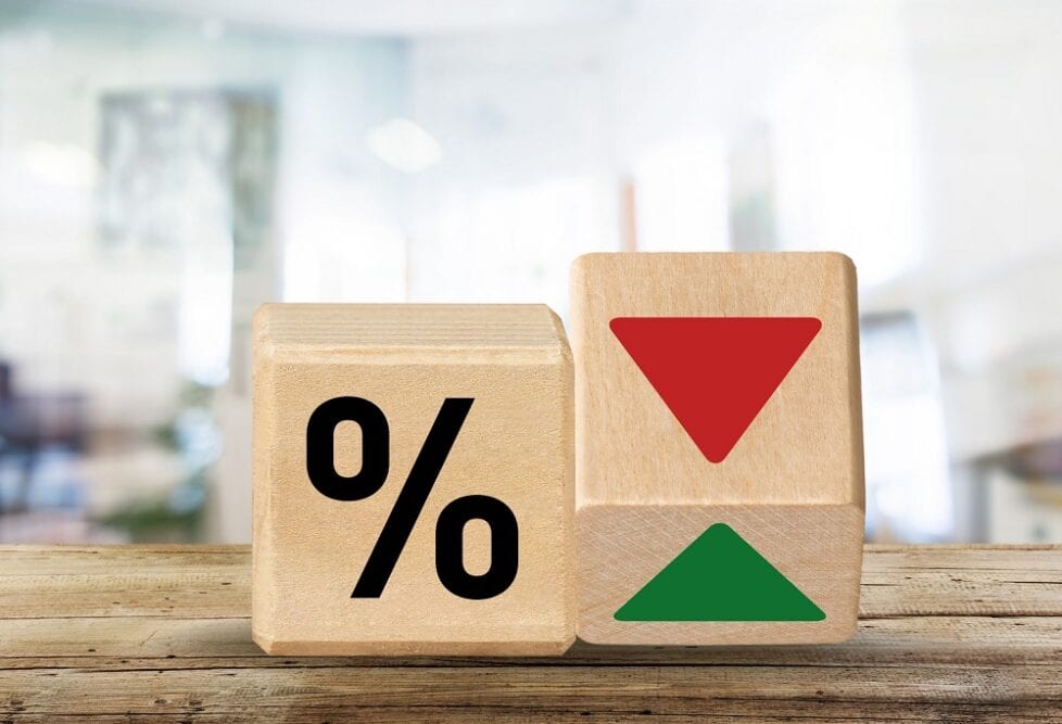 Two small wooden blocks. One shows the percentage symbol and the other is on one of its edges showing a down arrow and an up arrow.