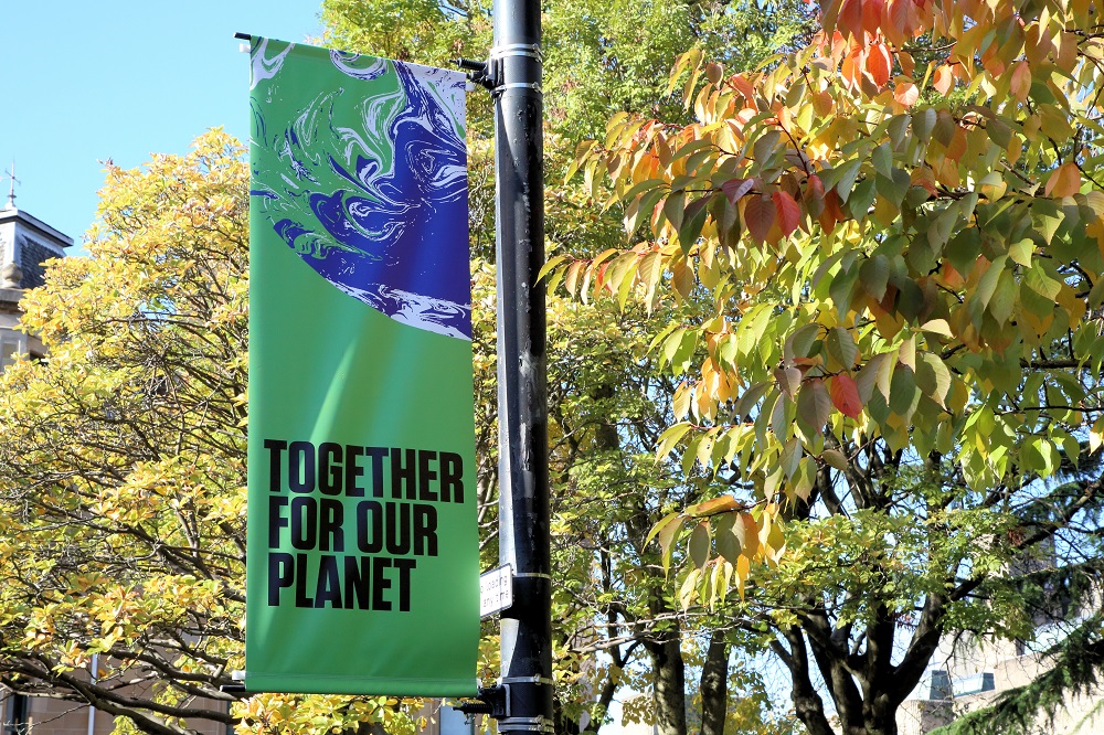 COP26 banner saying 'Together for our planet' on a street lamp.