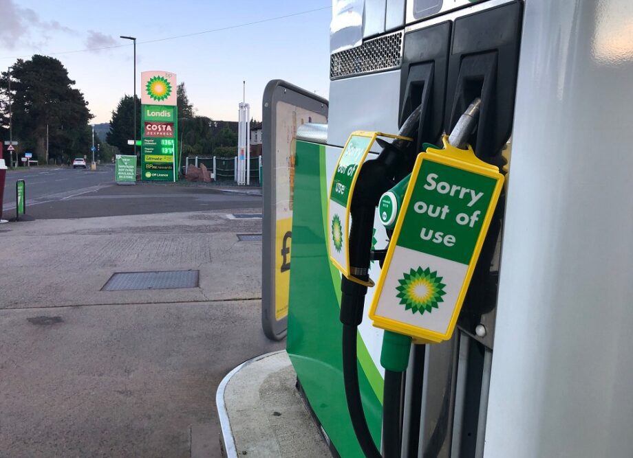 In the foreground there are petrol pumps with 'out of use' labels on them. In the background there is the petrol station forecourt with various signs including BP, Londis and Costa on the petrol station sign.
