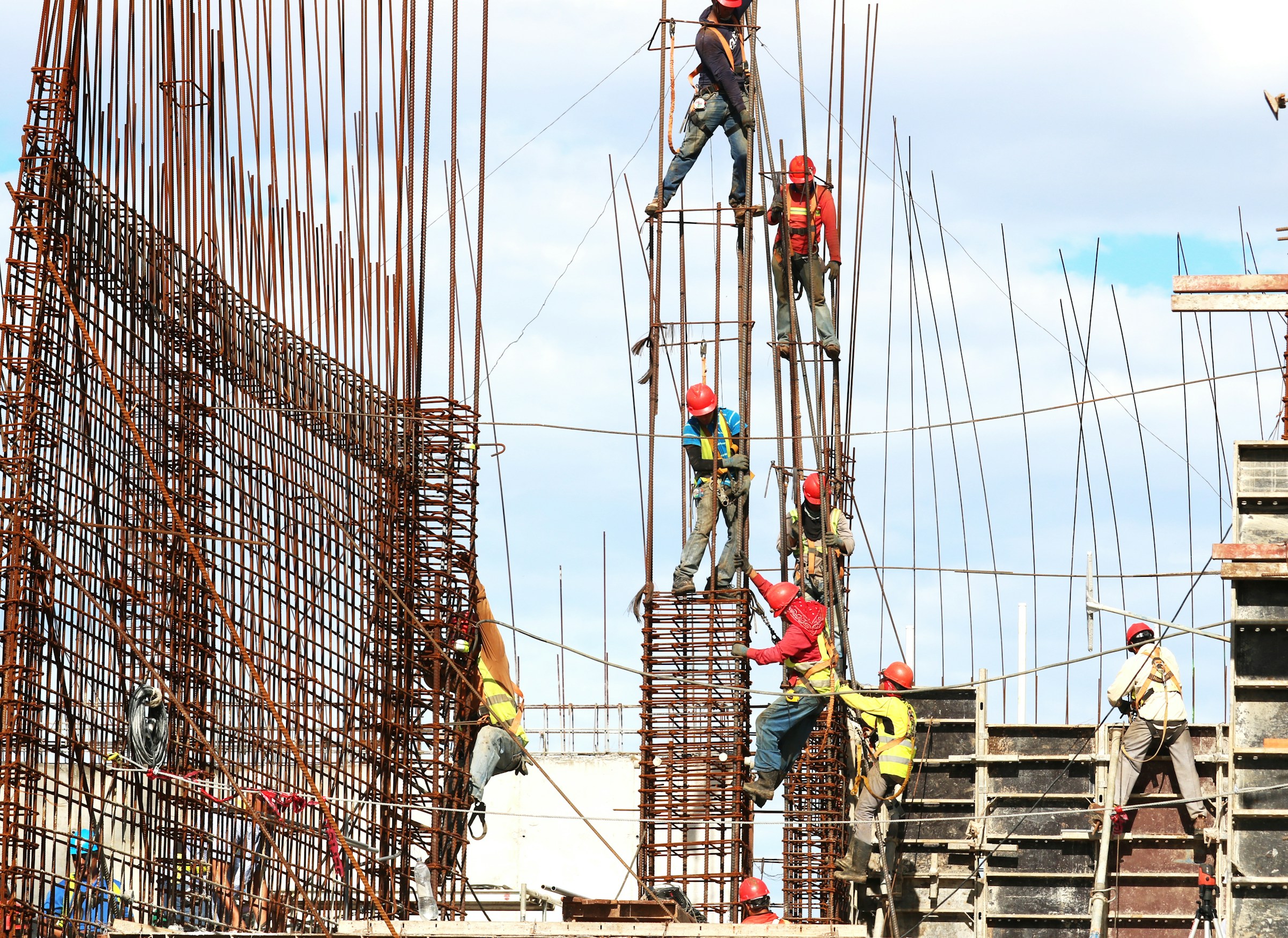 Construction workers climbing on scaffolding.