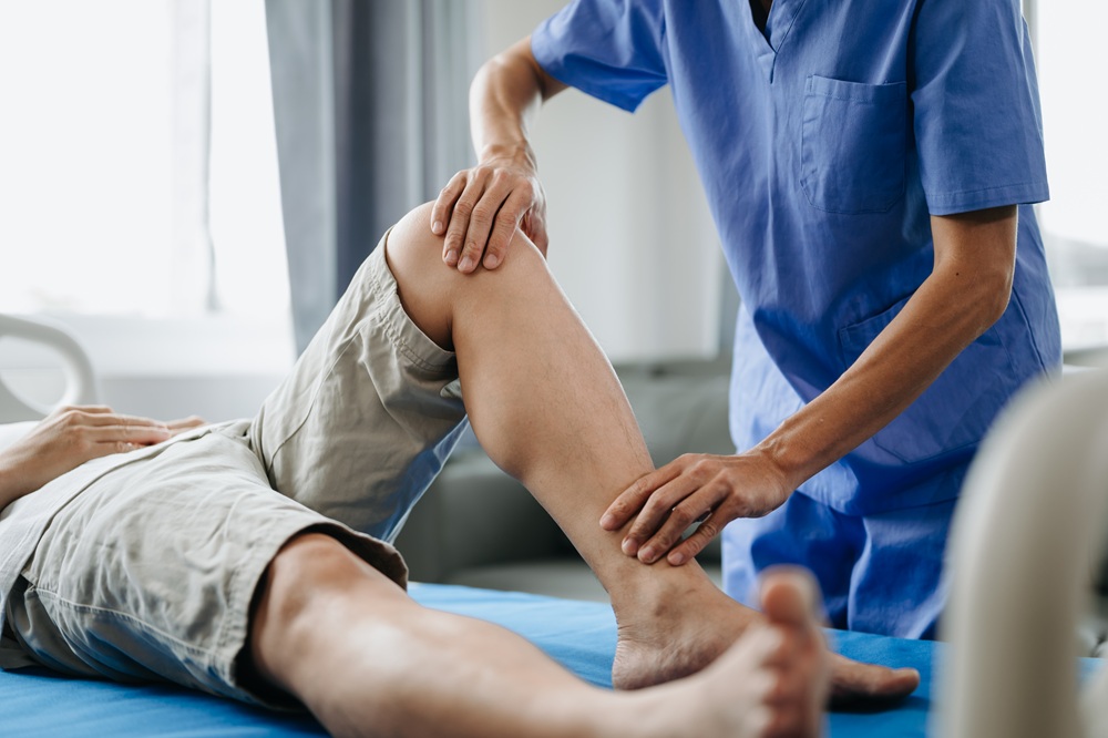 Close up of Physiotherapist working with patient on the bed in clinic. Credit: iStock Photo